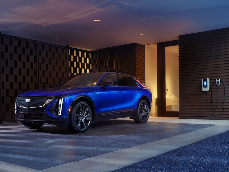 2025 Cadillac LYRIQ EV charging at a modern home.