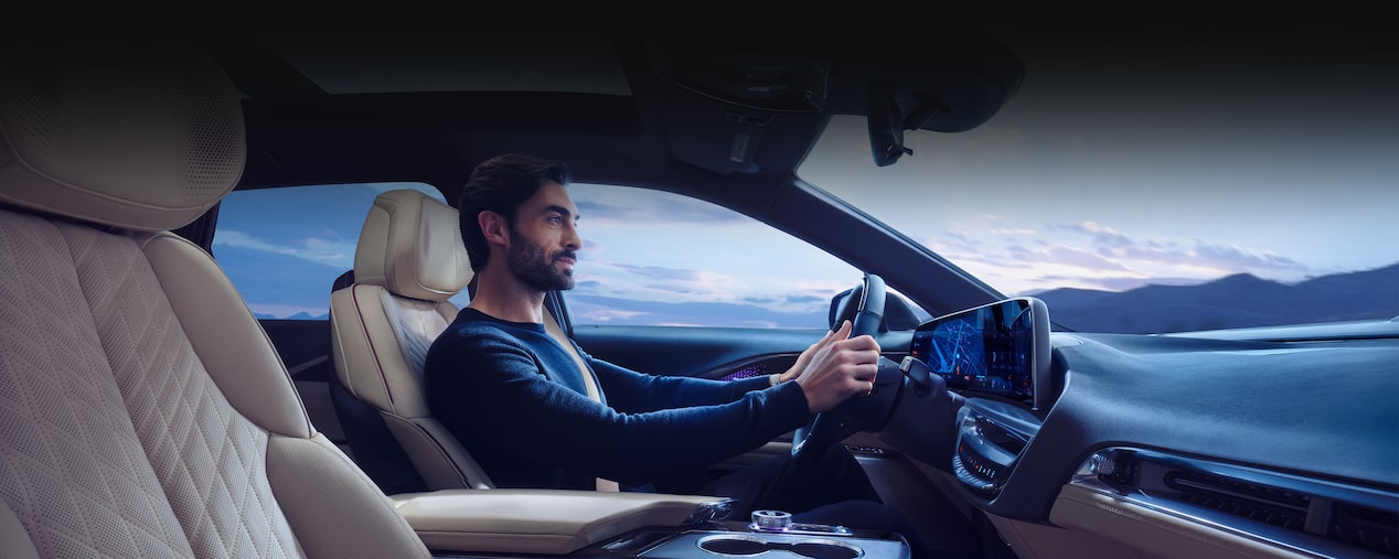 Side view of the front interiors of the 2025 Cadillac LYRIQ with a person seated at the driver's seat.