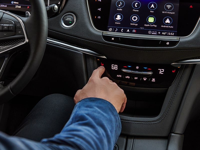 A person pressing the Air Ionizer button inside the 2025 Cadillac XT5 luxury SUV.