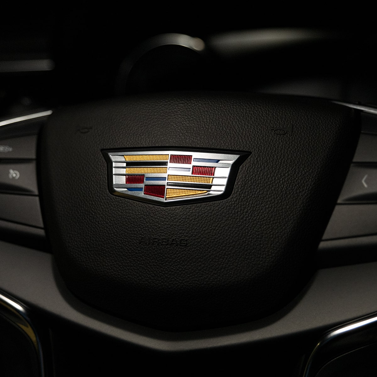 Close up view of the Cadillac insignia on the steering wheel of the 2025 Cadillac XT5 luxury SUV.