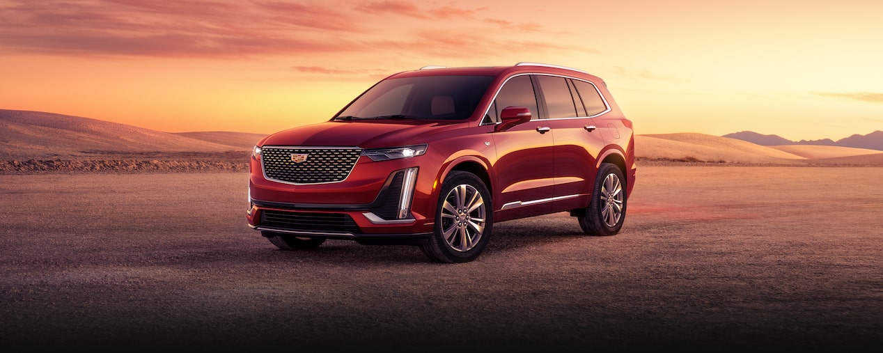 The 2025 Cadillac XT6 mid-size 7 passenger SUV parked alone during sunset.