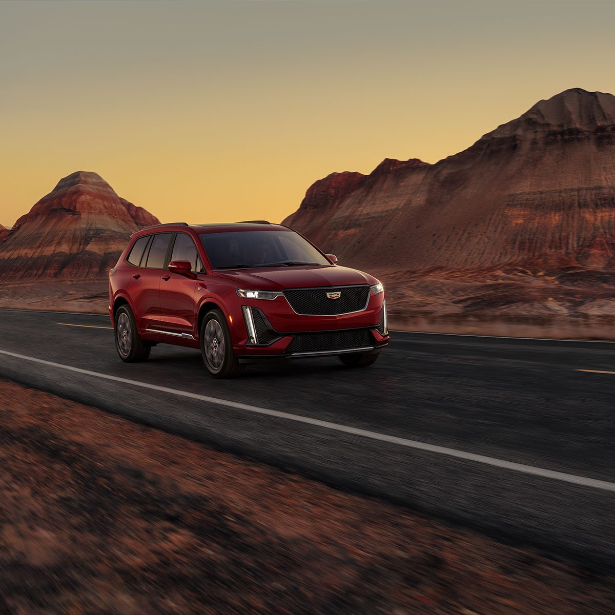 2025 Cadillac XT6 mid-size 7 passenger SUV driving by a canyon road.