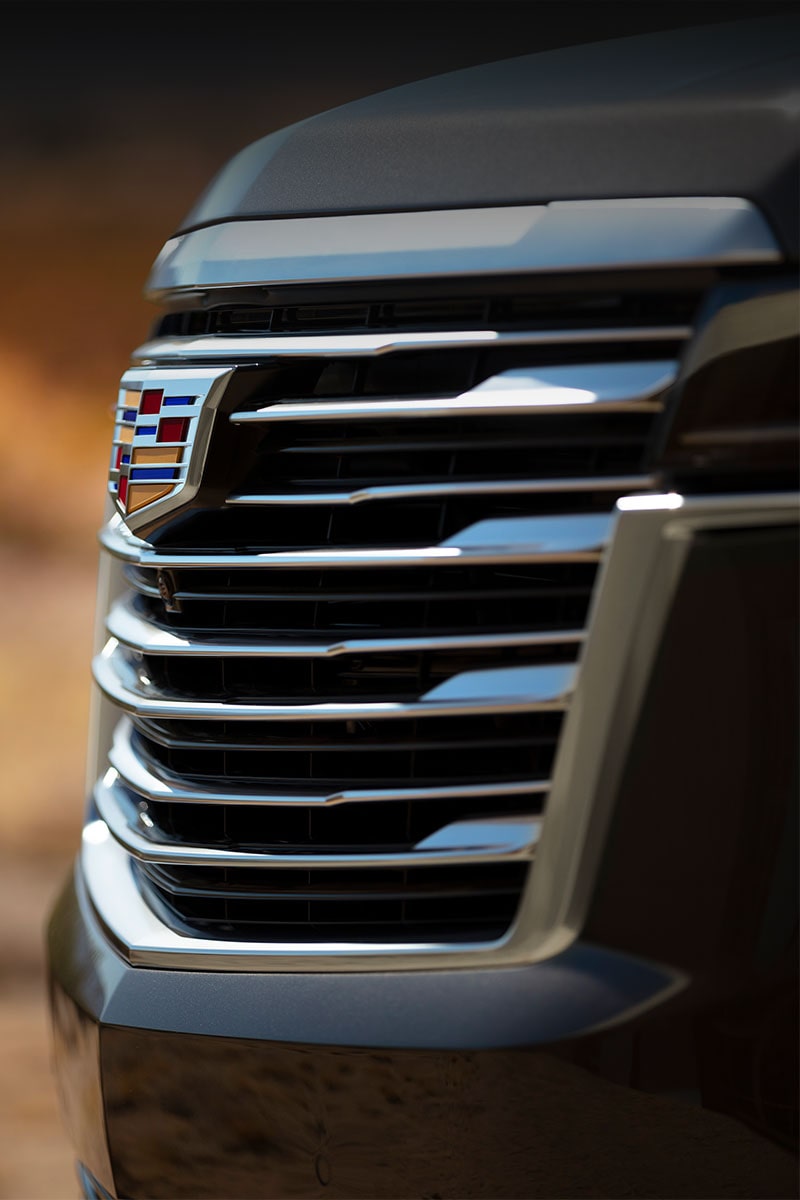 A side view close-up of a Cadillac SUV grille.