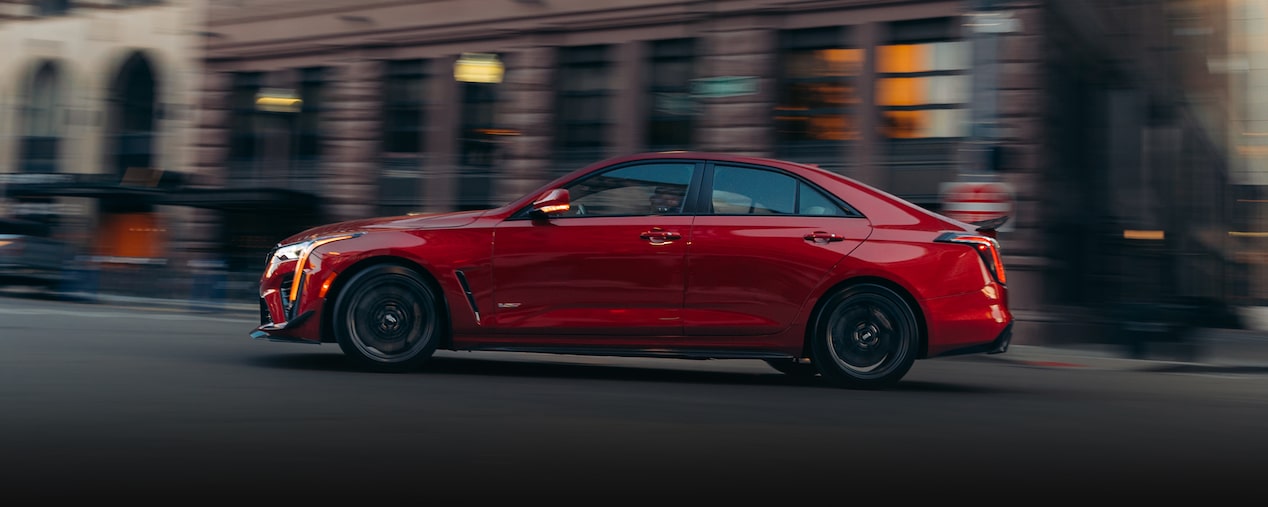 2025 Cadillac CT4-V luxury sports sedan driving on a road in the city.