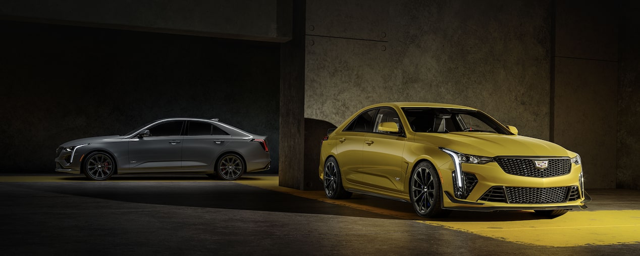 Two 2025 Cadillac CT4-V luxury sports sedans parked in a dark area.