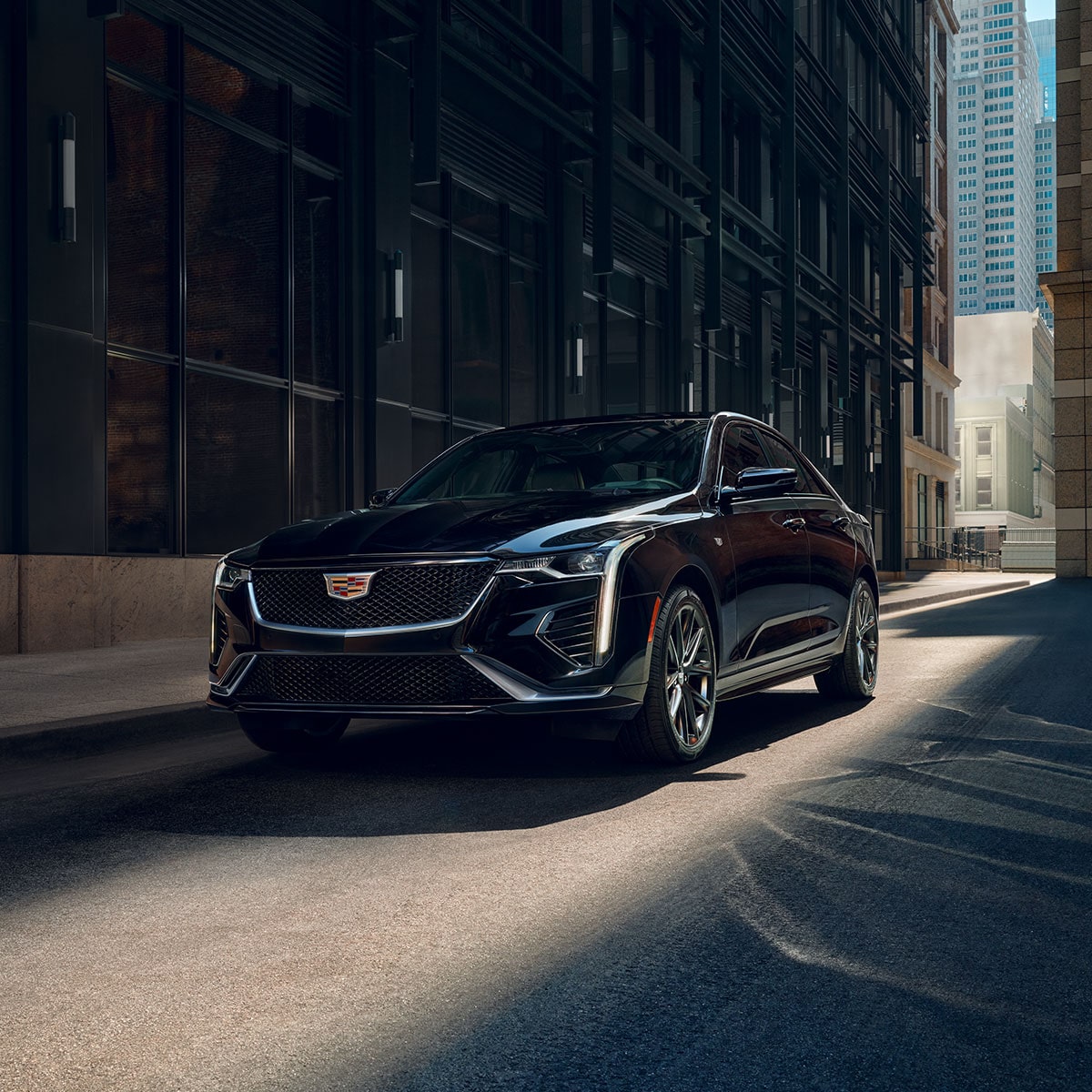 2025 Cadillac CT4 luxury sedan parked under the shade of a building.