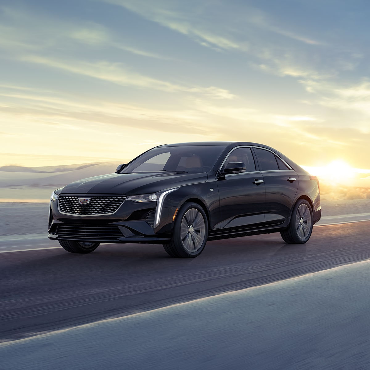 2025 Cadillac CT4 luxury sedan driving fast on a hillside road.