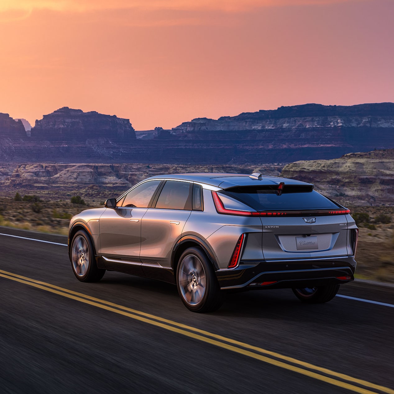 Behind shot of 2024 Cadillac LYRIQ driving down a highway.