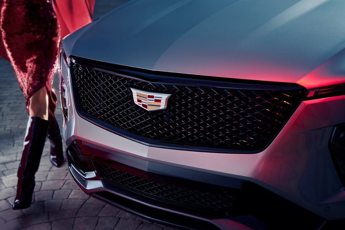 Front-side view of the front grilles of the 2025 Cadillac XT4 as a person passes by.