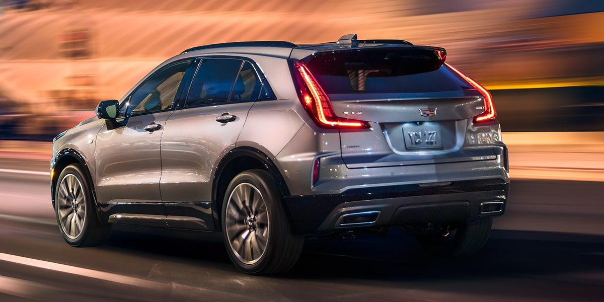 Back-side view of the 2025 Cadillac XT4 driving fast alone in the city.