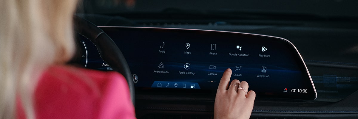 A person pressing the LED infotainment screen on the 2025 Cadillac XT4.