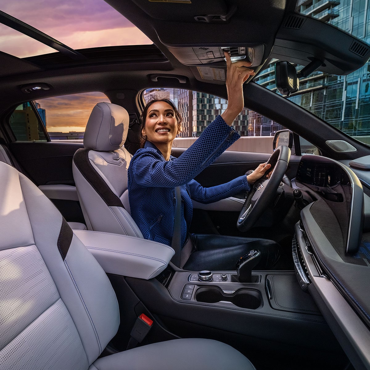 Side view of the front interiors and sunroof of the 2025 Cadillac XT4 while a person is seated at the driver's seat. 