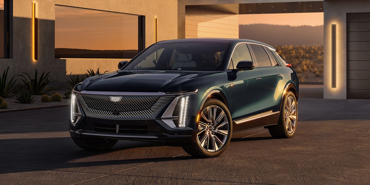 The 2024 Cadillac Lyriq parked on a pavement under a dimly lit area.