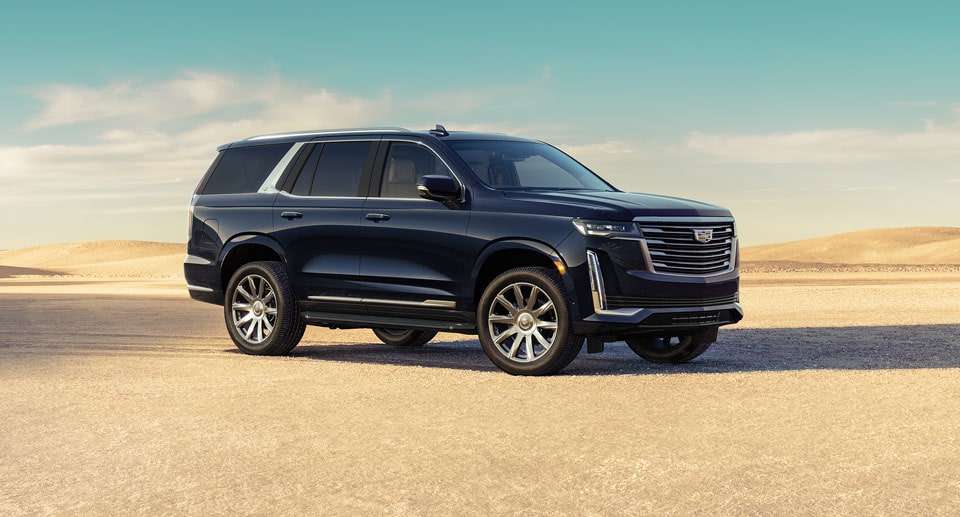 Cadillac Escalade parked on sand.