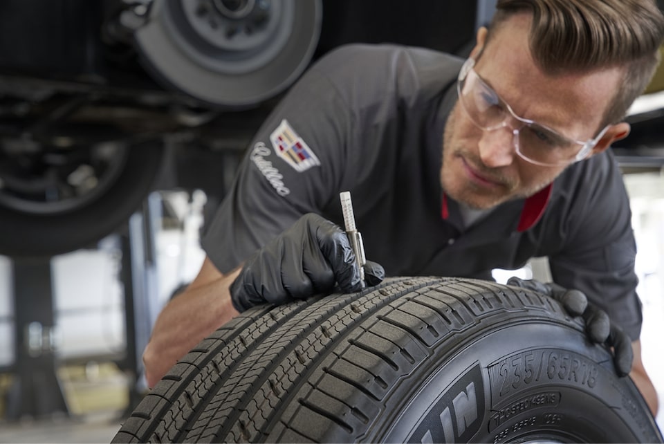 Cadillac Protection Expert checking a tire.