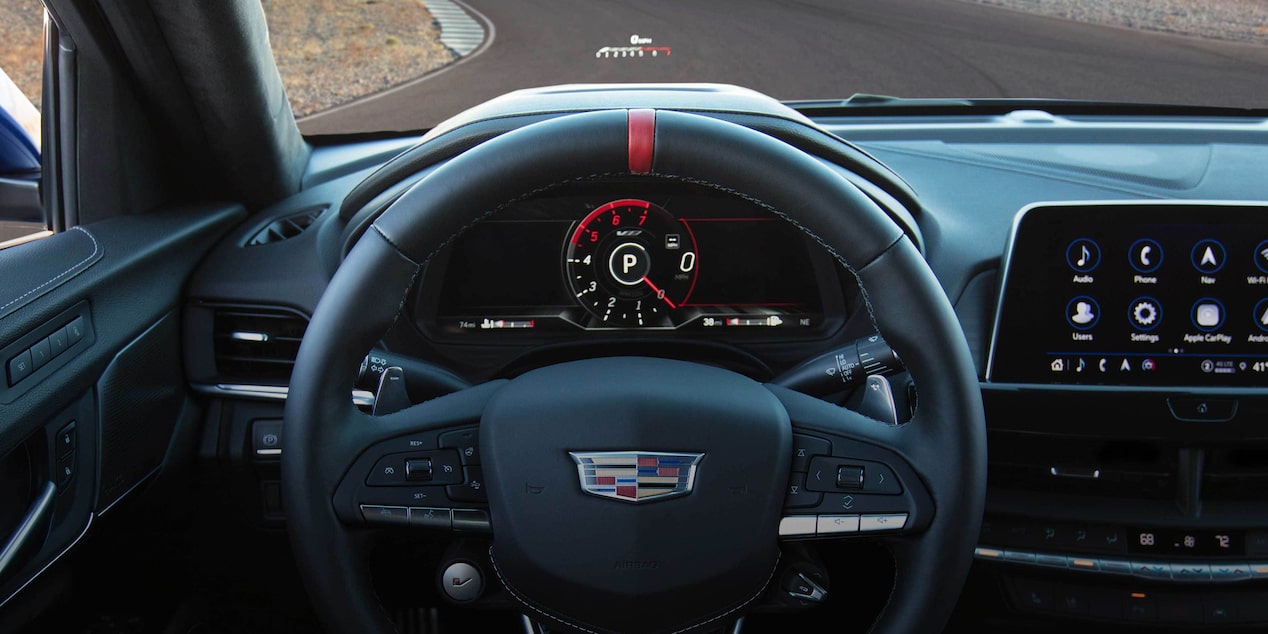 Front interior of the 2023 Cadillac CT4-V compact sport sedan featuring the steering wheel and heads-up display.